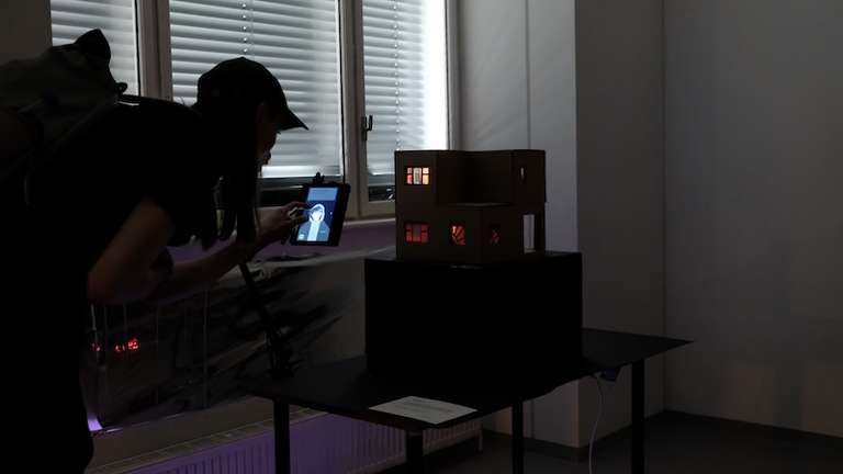 A person is crouching down to look at a screen that is being used in 